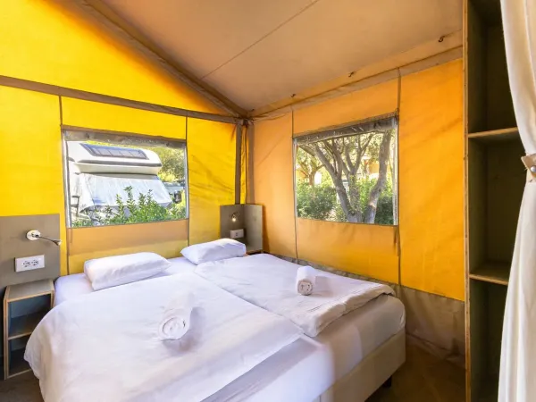 De Roan Lodgetent premium slaapkamer met ruim tweepersoonsbed.