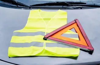 Een geel veiligheidsvest en gevarendriehoek die verplicht in de auto moeten liggen.