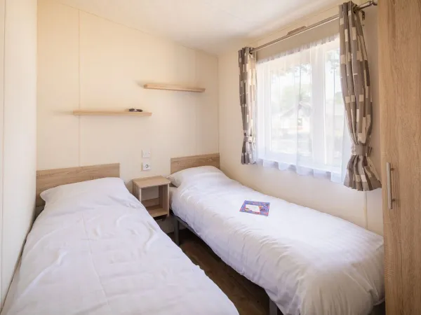 Eerste slaapkamer met twee éénpersoonsbedden binnen de Comfort Lounge.