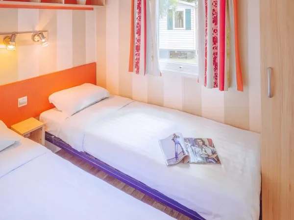 Roan Comfort Plus Lounge slaapkamer met twee eenpersoonsbedden.