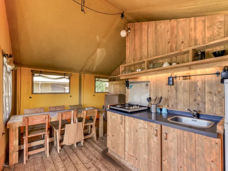 De Roan Lodgetent Luxe beschikt over een keuken met hoge koelkast en uitgebreid keukeninventaris.