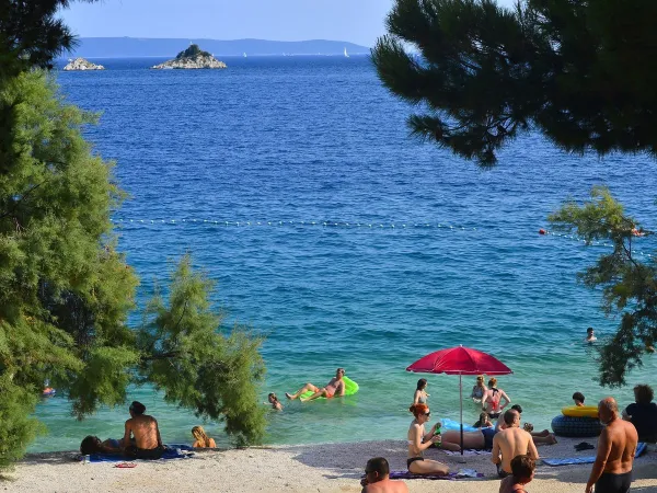 Strand met blauwe zee bij Roan camping Amadria Park Trogir.