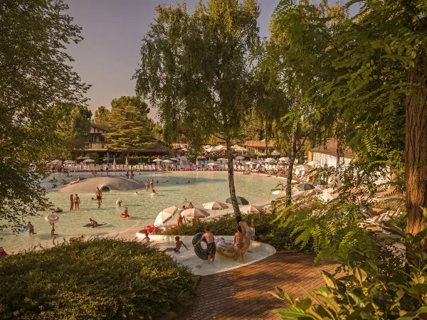 Lagune zwembad met brede glijbanen en glijheuvels op Roan camping hu Altomincio village.