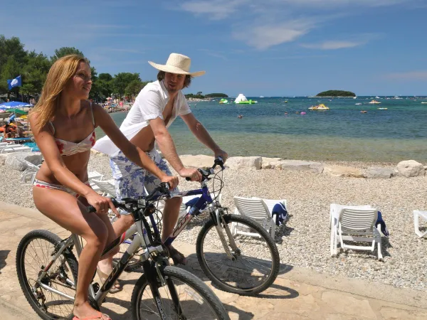 Fietsen langs het kiezelstrand op Roan camping Valkanela.