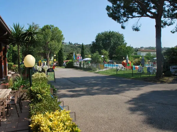 Overzicht van het terras en de speeltuin op Roan camping La Rocca Manerba.