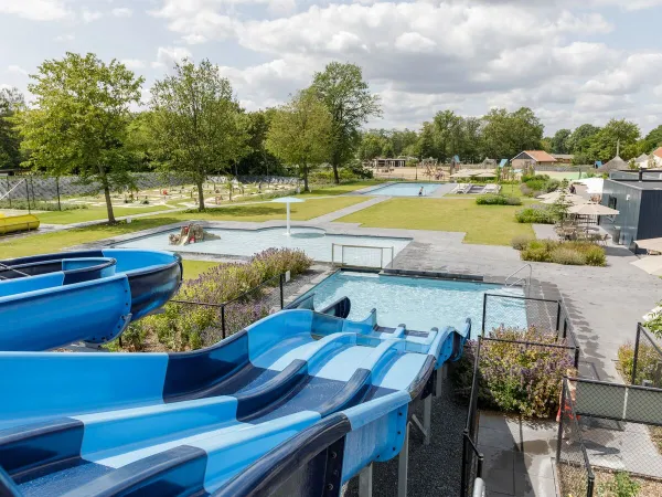 Overzicht glijbanen buitenzwembad bij Roan camping De Twee Bruggen.