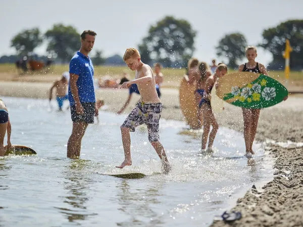 Surfboarden in de waterplas bij Roan camping Terspegelt.