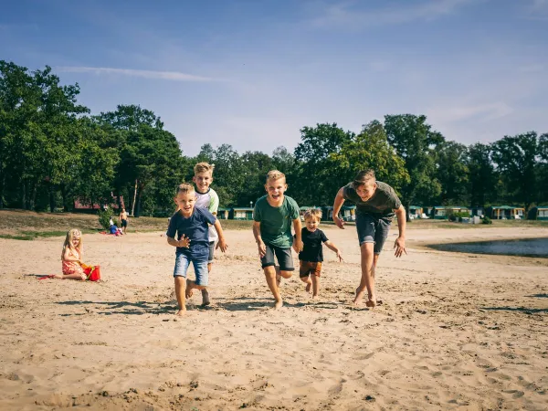 Het zandstrand bij het natuurbad op Roan camping De Schatberg.