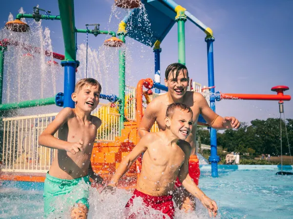 Zwemmen in het buiten zwembad met waterspeeltuin bij Roan camping De Schatberg.