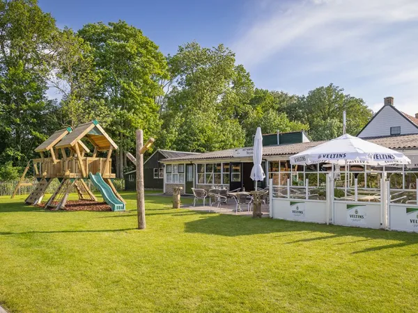 Het terras met speeltuin bij Roan camping Marvilla Parks Friese Meren.