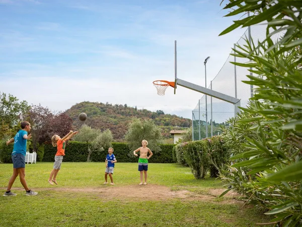 Kinderen basketballen op Roan camping La Rocca Manerba.