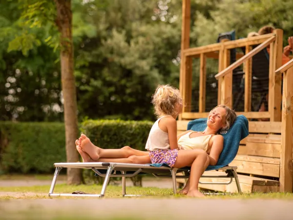 Moeder die zont bij de lounge van de accomodatie.