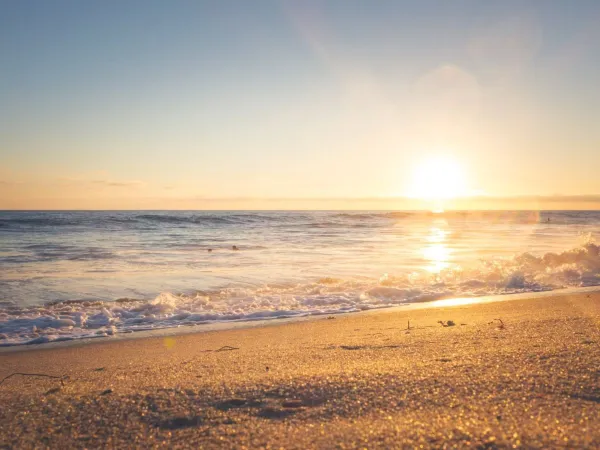 Ondergaande zon op het strand Roan camping Rimini Family Village.