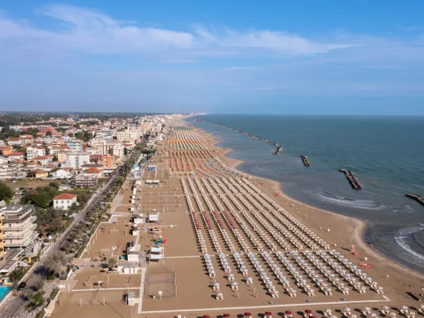 Overzicht van kustlijn met zandstrand bij Roan camping Rimini Family Village.