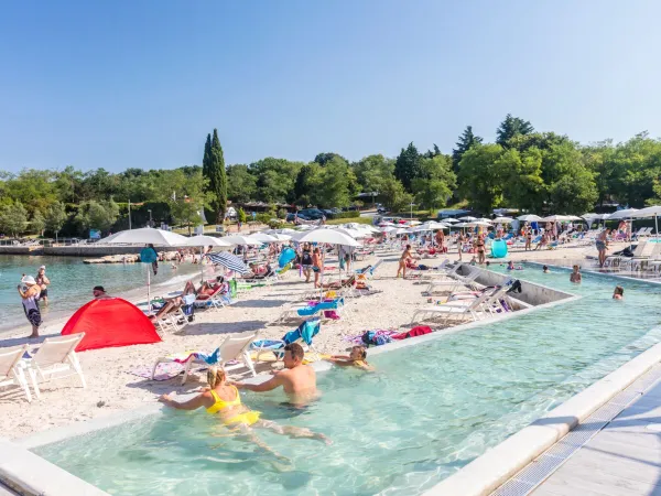 Infinity zwembad op het zandstrand bij Roan camping Lanterna.