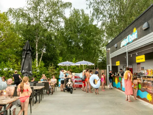 Mensen halen iets lekkers bij de poolbar op Roan camping hu Birkelt village.