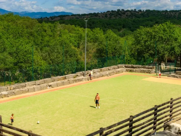 Voetballen op het sportveld bij Roan camping Aluna Vacances.
