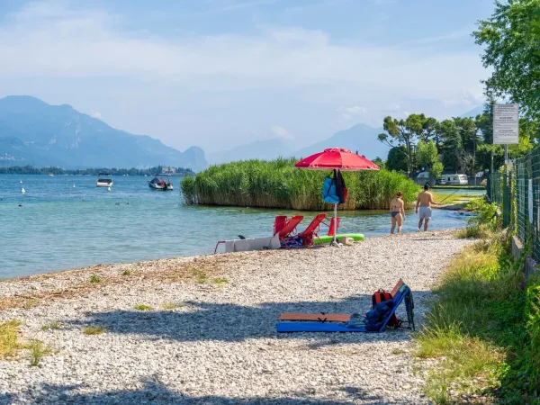 Het kiezelstrand op Roan camping La Rocca Manerba.