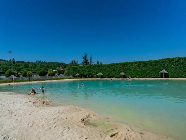 Het paradijselijke lagunebad met strand op Roan camping Chateau de Galaure.