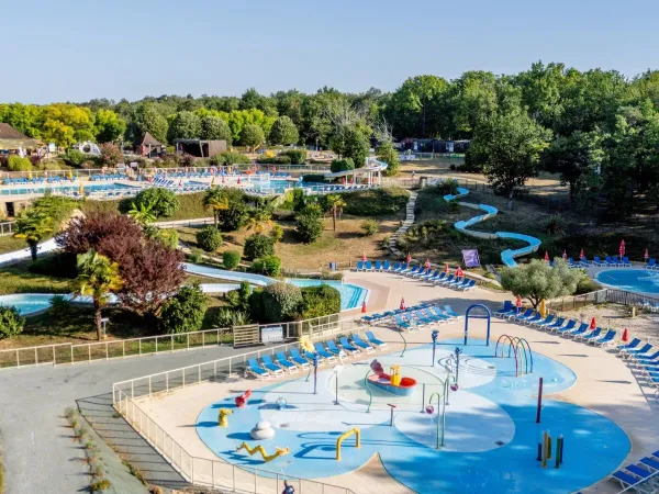 Overzicht van het waterpark en de zwembaden in de verte op Roan camping Saint Avit Loisirs