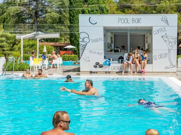 Mensen die zwemmen en relaxen bij de poolbar op Roan camping Valkanela.
