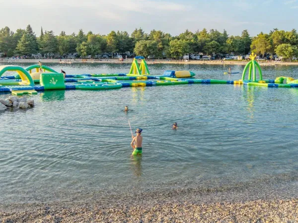Zee met speel en springkussens in het water op Roan camping Valkanela.