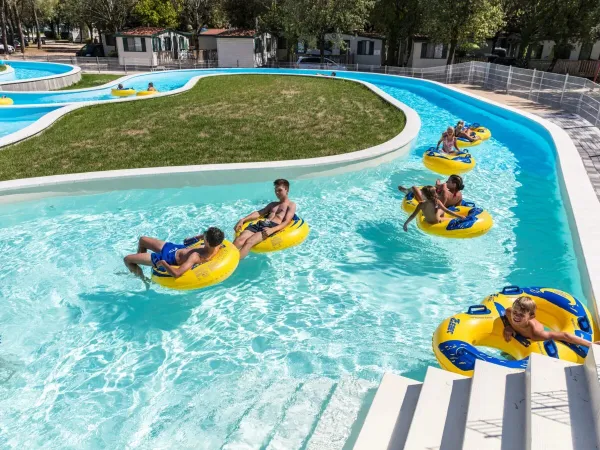 Kinderen in de banden op de lazy River op Roan camping Marina Julia Camping Village.