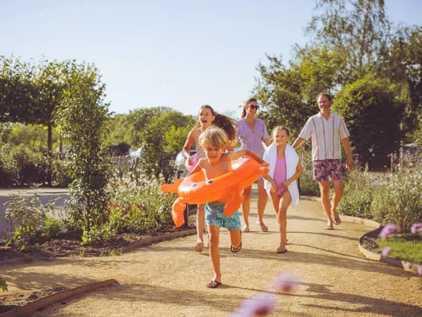 Familie rent naar het zwembad.