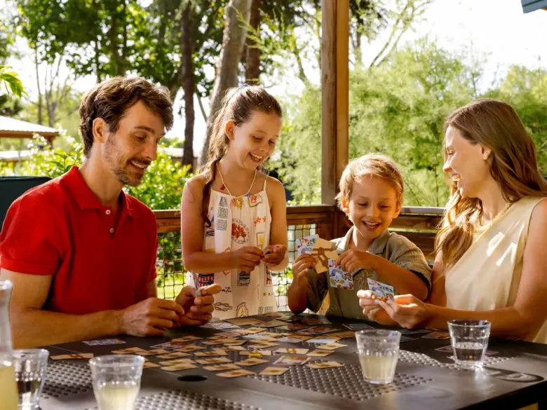Familie doet een spelletje op Roan camping Village Bella Iseo.