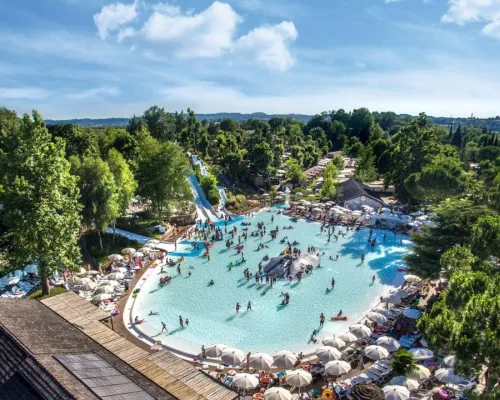 Overzicht lagune zwembad met glijheuvels en glijbanen op Roan camping Altomincio.