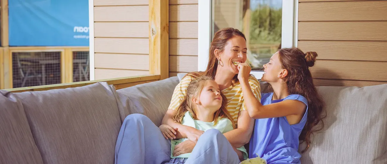 Vrouw ligt een boek te lezen in de zon bij een Roan stacaravan.