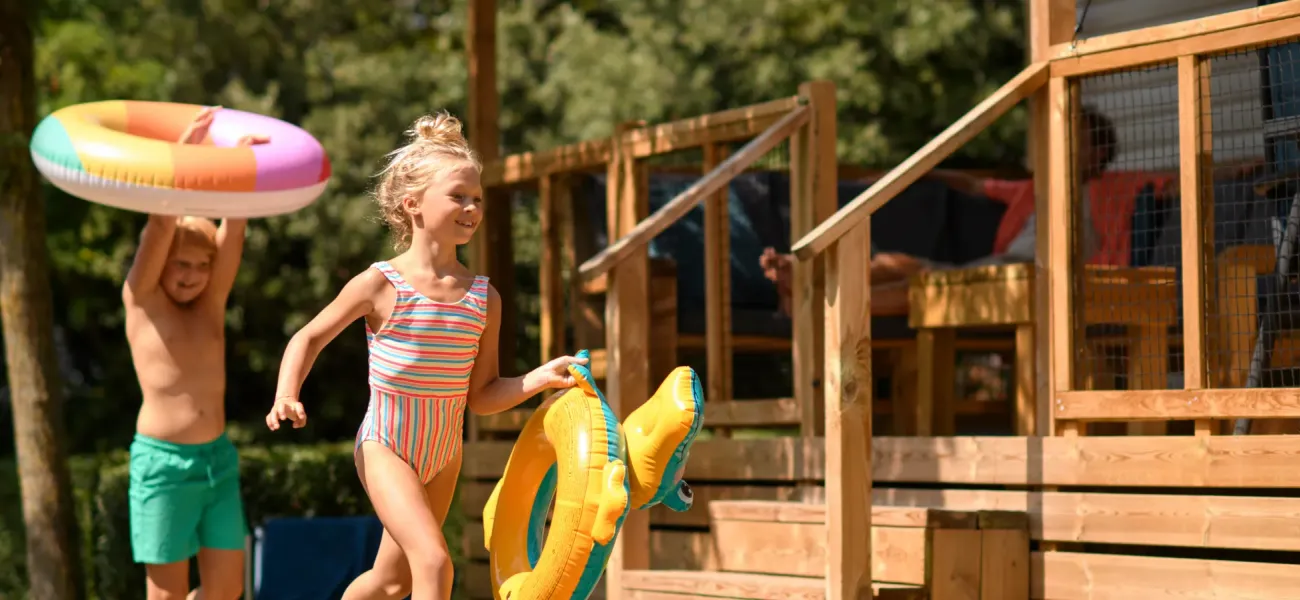 Kind op kinderfiets met campingmedewerkers